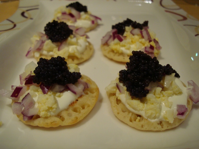 Blinis with sour cream, egg, onion and fake caviar